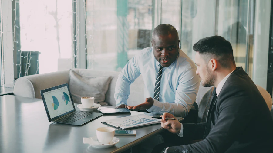 Two business professionals reviewing performance charts on a laptop